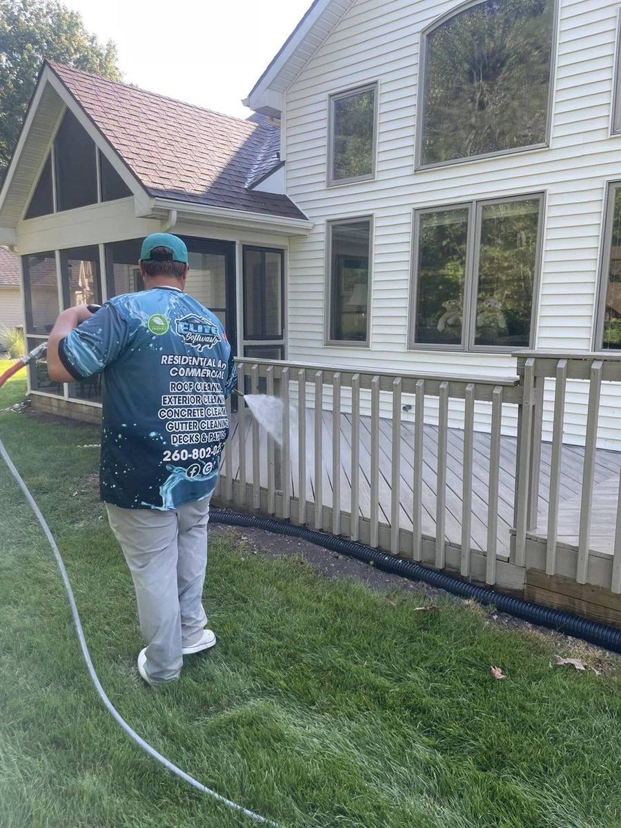 Elite Softwash technician cleaning a deck and exterior of a northern Indiana home